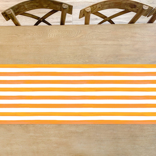 Orange and white striped table runner by Cami Monet, 16.5" x 96", featuring bold horizontal stripe design for table decor.