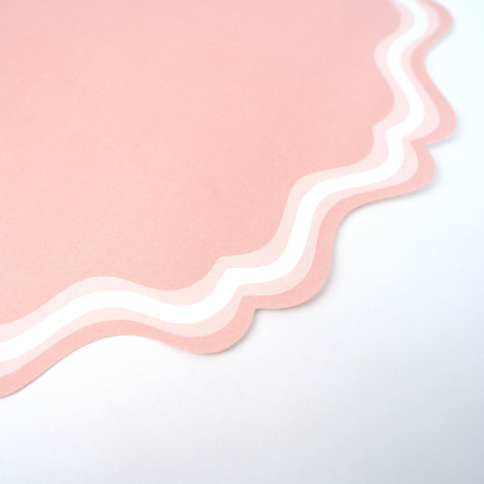 Pink fancy scallop paper placemats from Gatherings by Curated Paperie, 12 count, featuring elegant scalloped edges and decorative design.