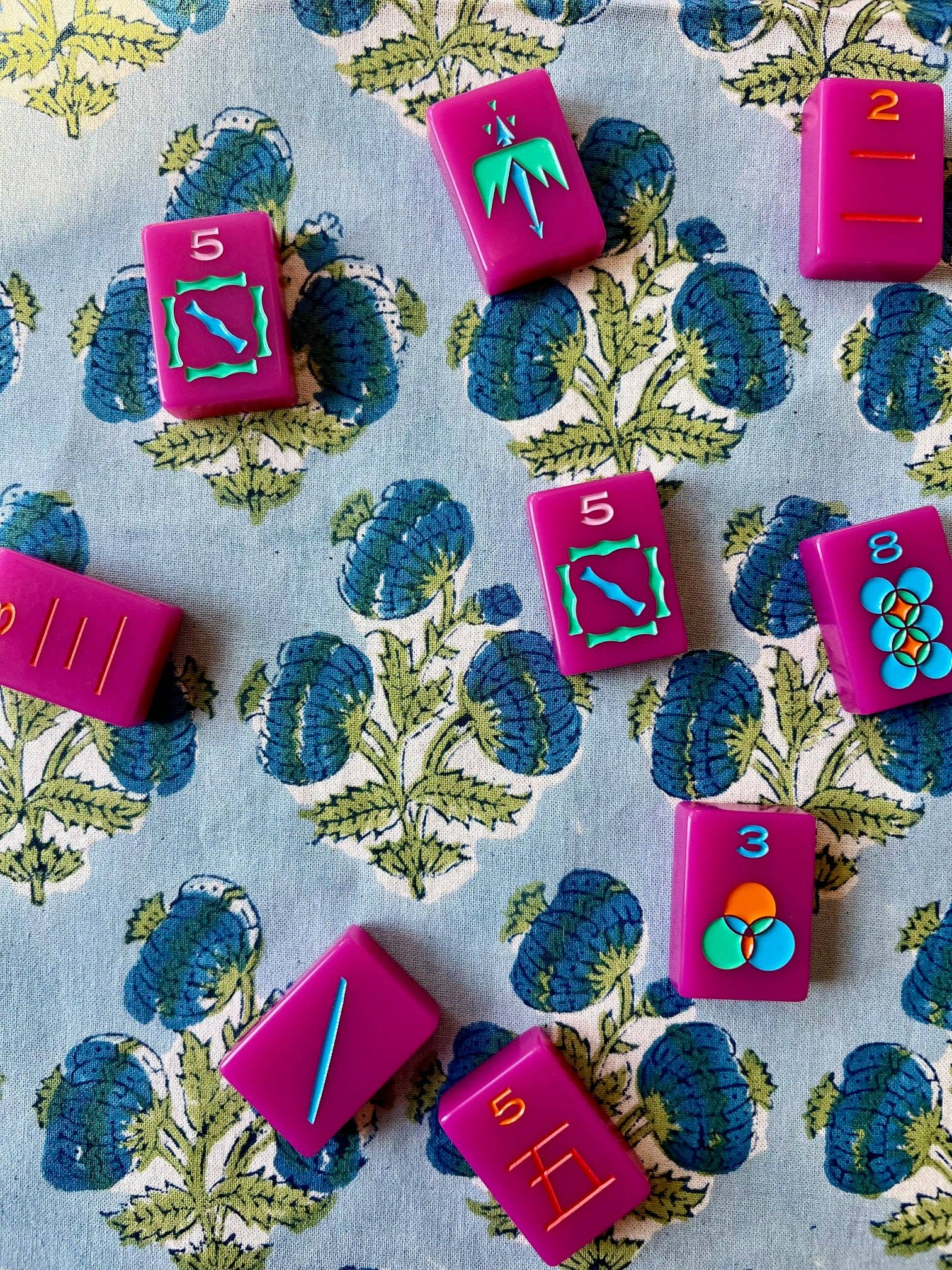 Blue Poms Tablecloth by Christina Dickson Home, 60x60 inches, featuring a vibrant bluebird pattern on a fabric surface.