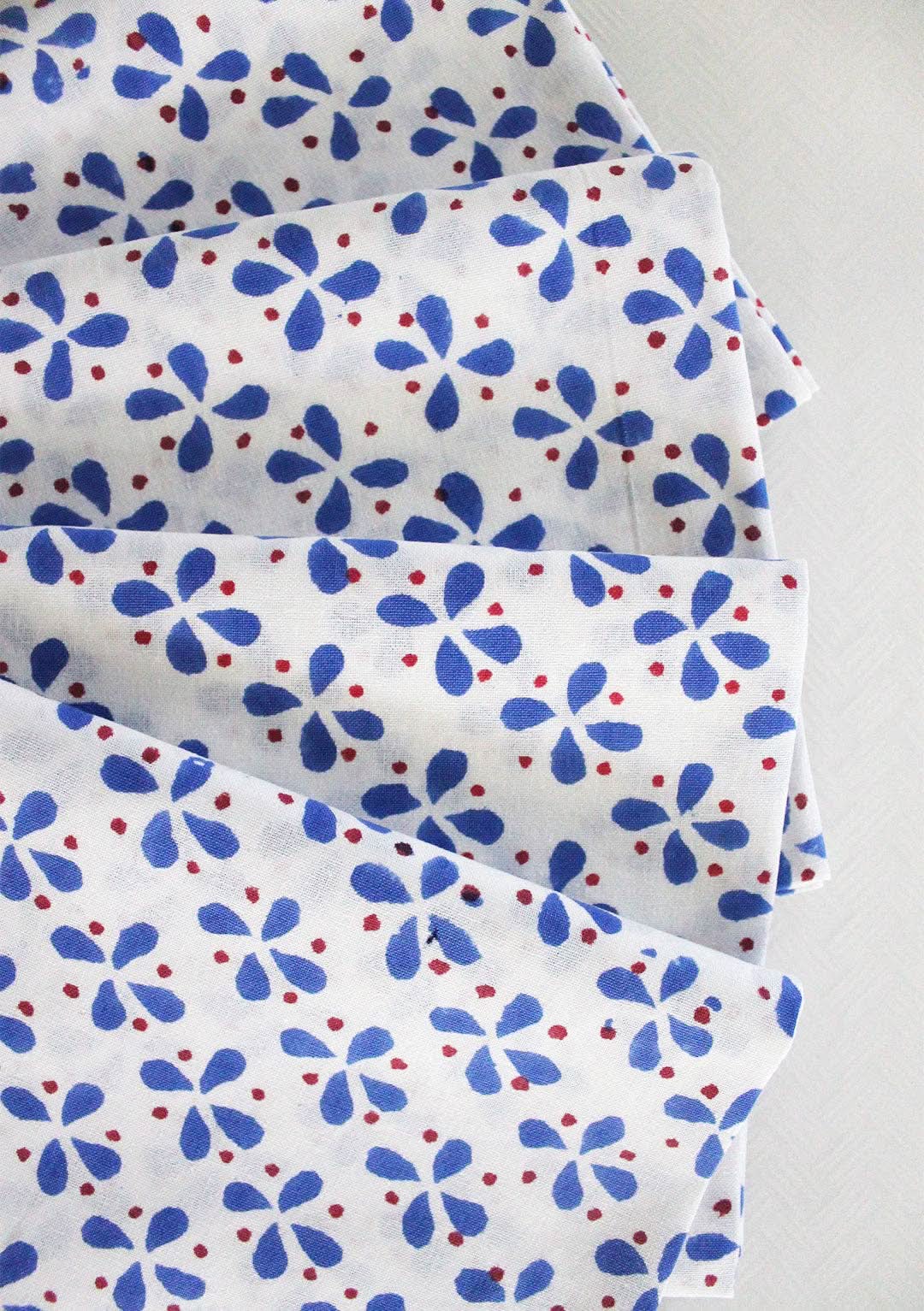 Set of four Christina Dickson Home Petals Napkins in vibrant royal blue, featuring a floral petal design for elegant table settings.
