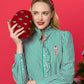 Shiraleah Trees Minaudière in crimson with a floral tree design, featuring a metallic clasp and compact rectangular shape.