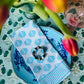 Set of four turquoise Coral Flame napkins by Christina Dickson Home, featuring vibrant coral flame patterns on soft fabric.