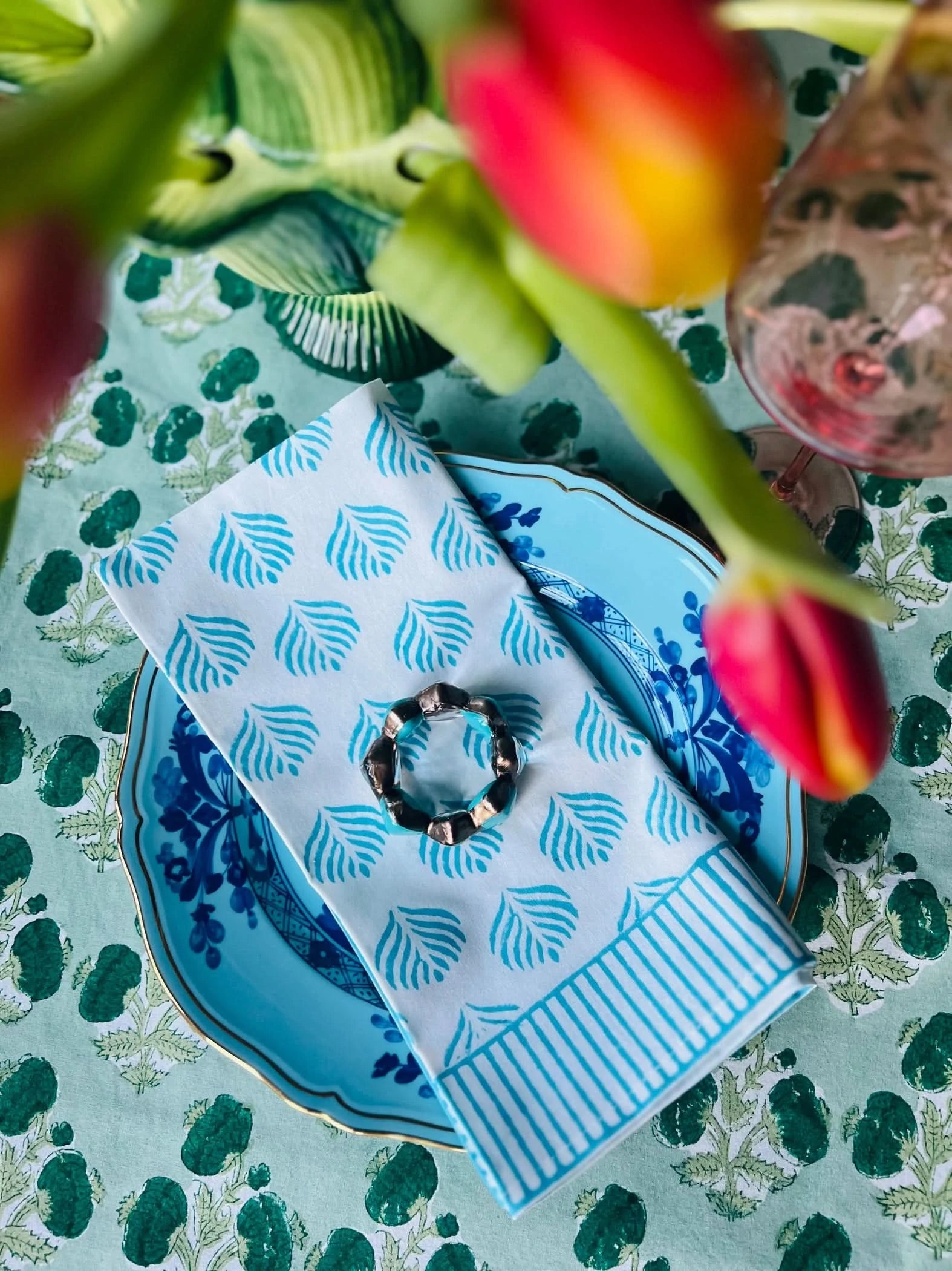 Set of four turquoise Coral Flame napkins by Christina Dickson Home, featuring vibrant coral flame patterns on soft fabric.
