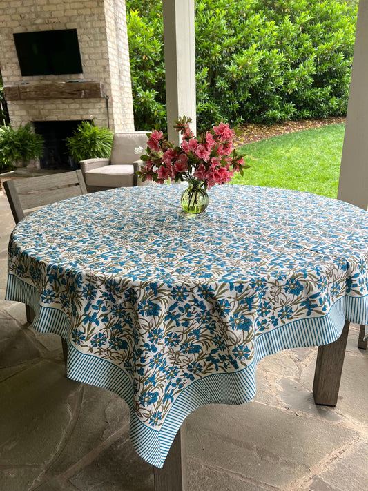 Blue Pinwheel Tablecloth by Christina Dickson Home, 120x70 inch rectangle, featuring a vibrant bluebird pattern on fabric.
