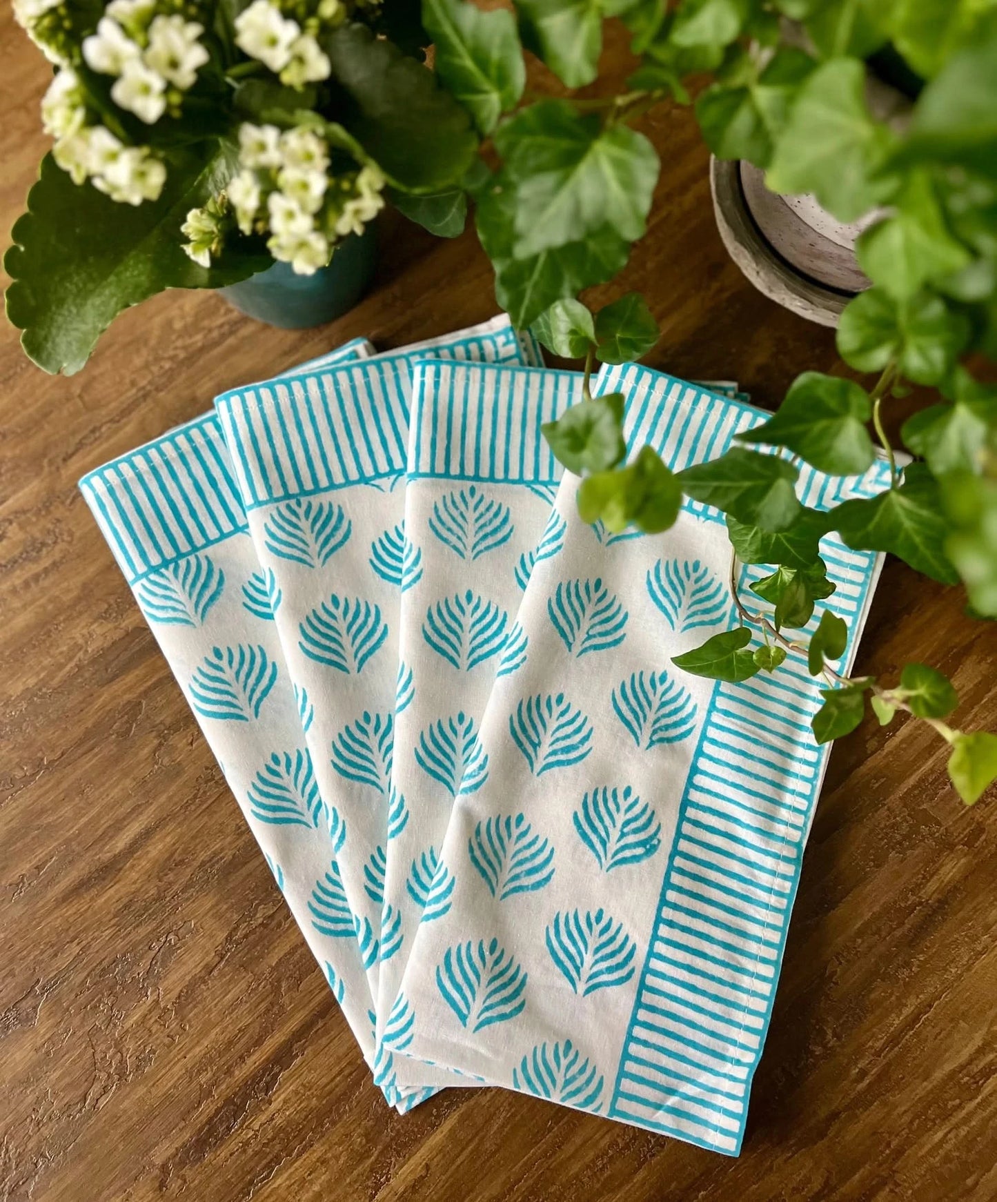 Set of four turquoise Coral Flame napkins by Christina Dickson Home, featuring vibrant coral flame pattern for elegant table decor.