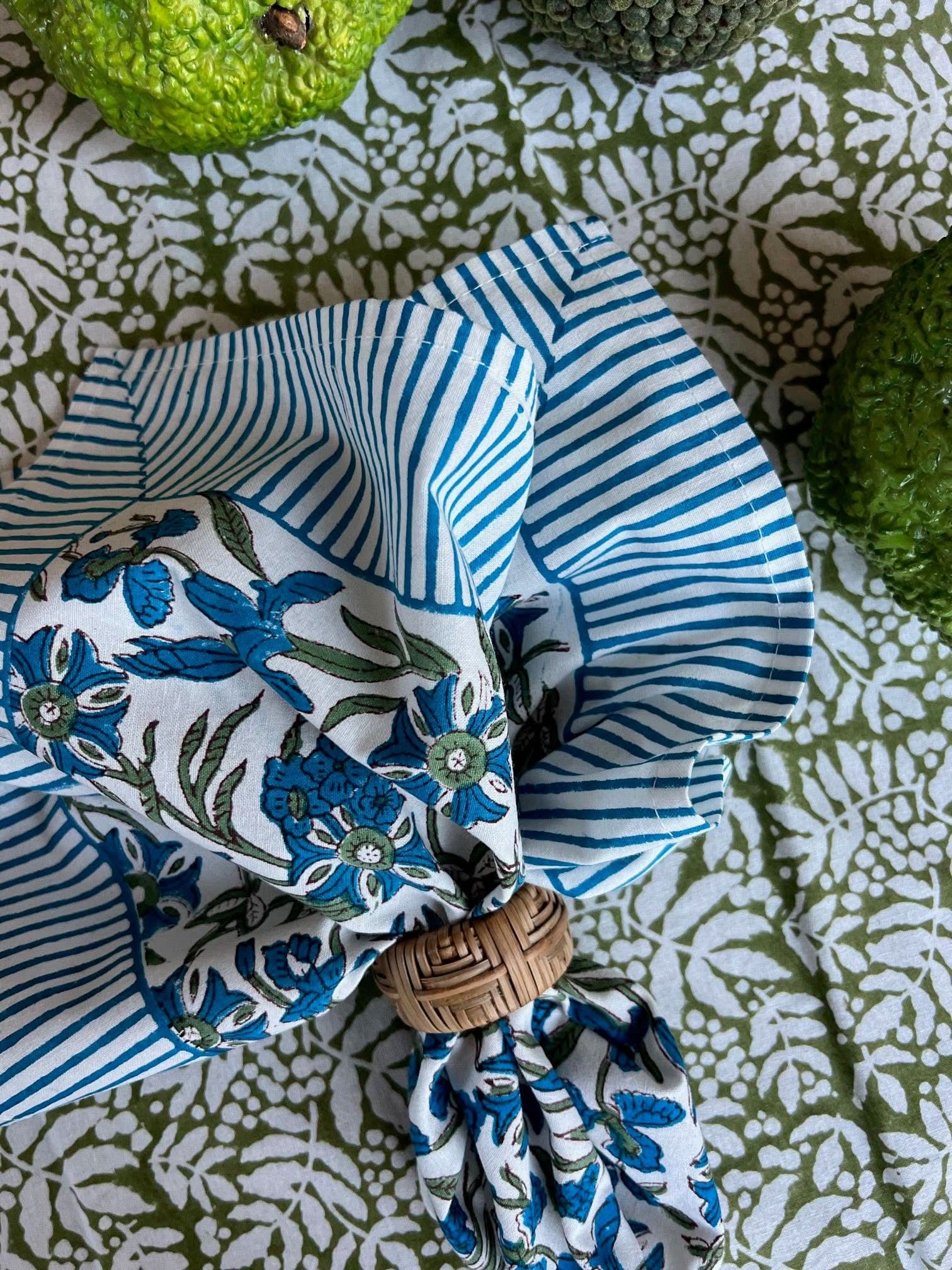 Set of four Christina Dickson Home Pinwheel Napkins in Bluebird with bright, colorful pinwheel patterns on soft fabric.