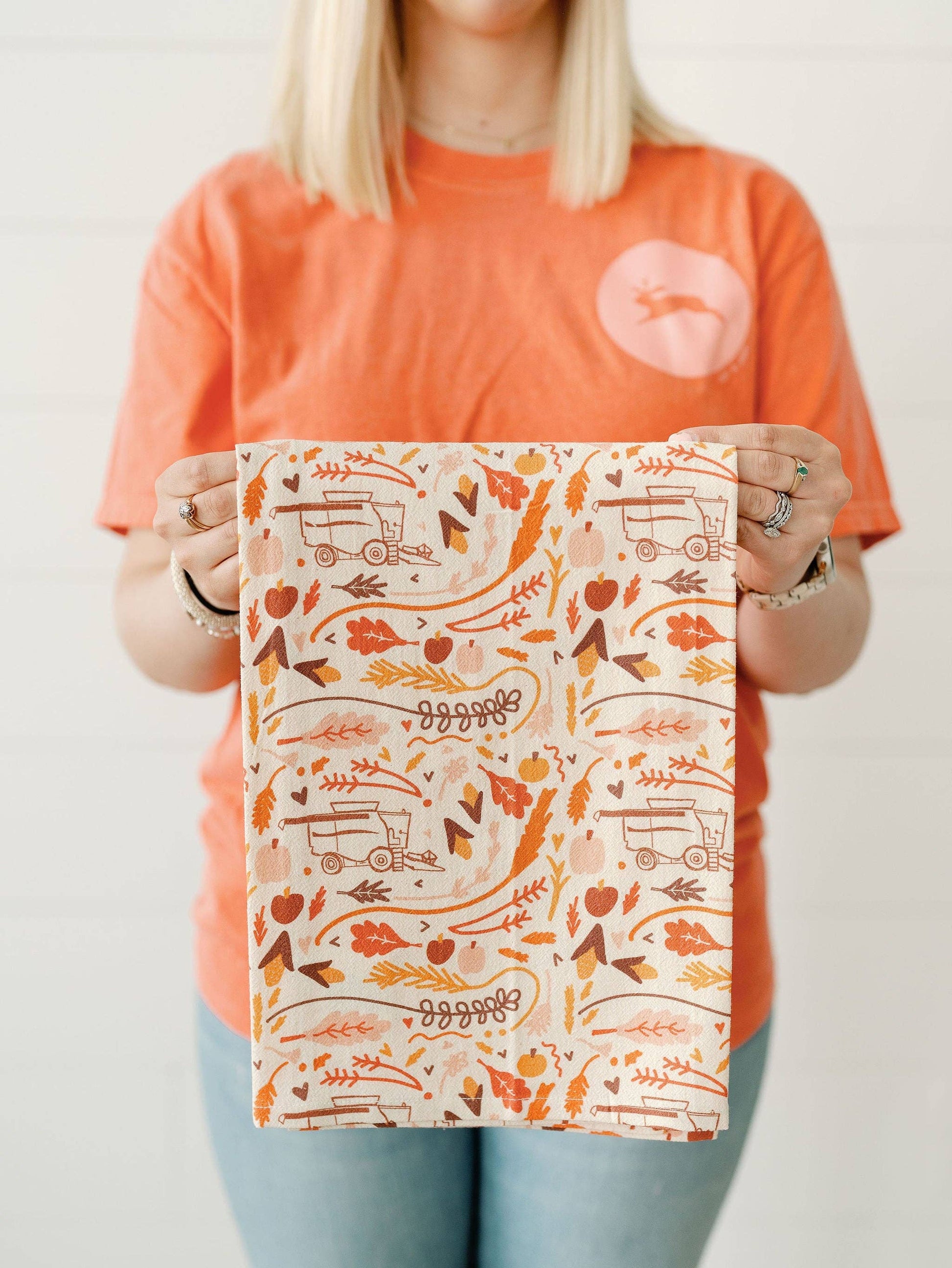 Fall full pattern flour sack towel by Doe A Deer featuring harvest-themed autumn leaves and pumpkins in warm fall colors.