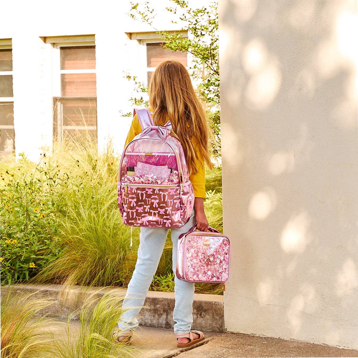 Pink lunchbox decorated with bows and confetti, featuring a playful and colorful design by Packed Party.