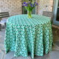 Emerald green Poms tablecloth by Christina Dickson Home, 120x70 inch rectangle, fabric with colorful pom trim for dining table.