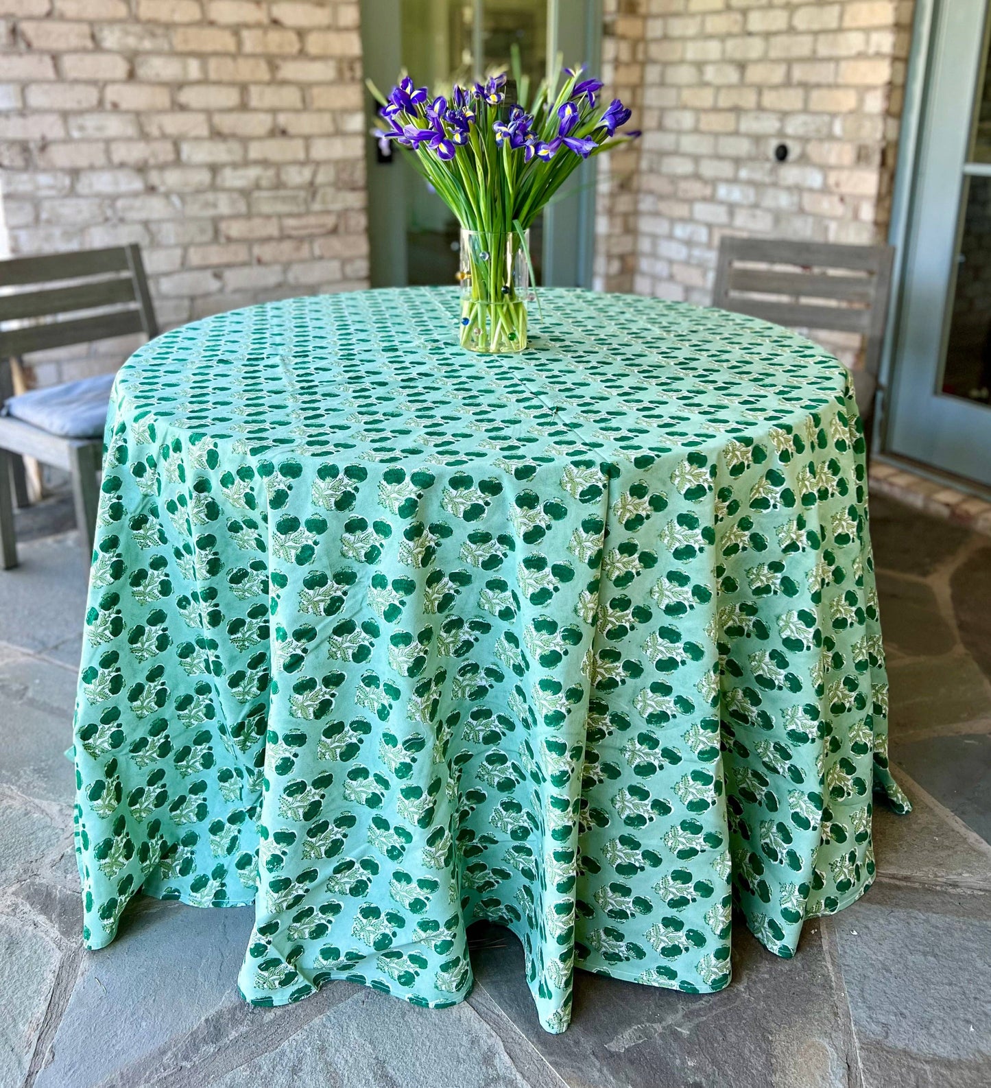 Emerald green Poms tablecloth by Christina Dickson Home, 120x70 inch rectangle, fabric with colorful pom trim for dining table.