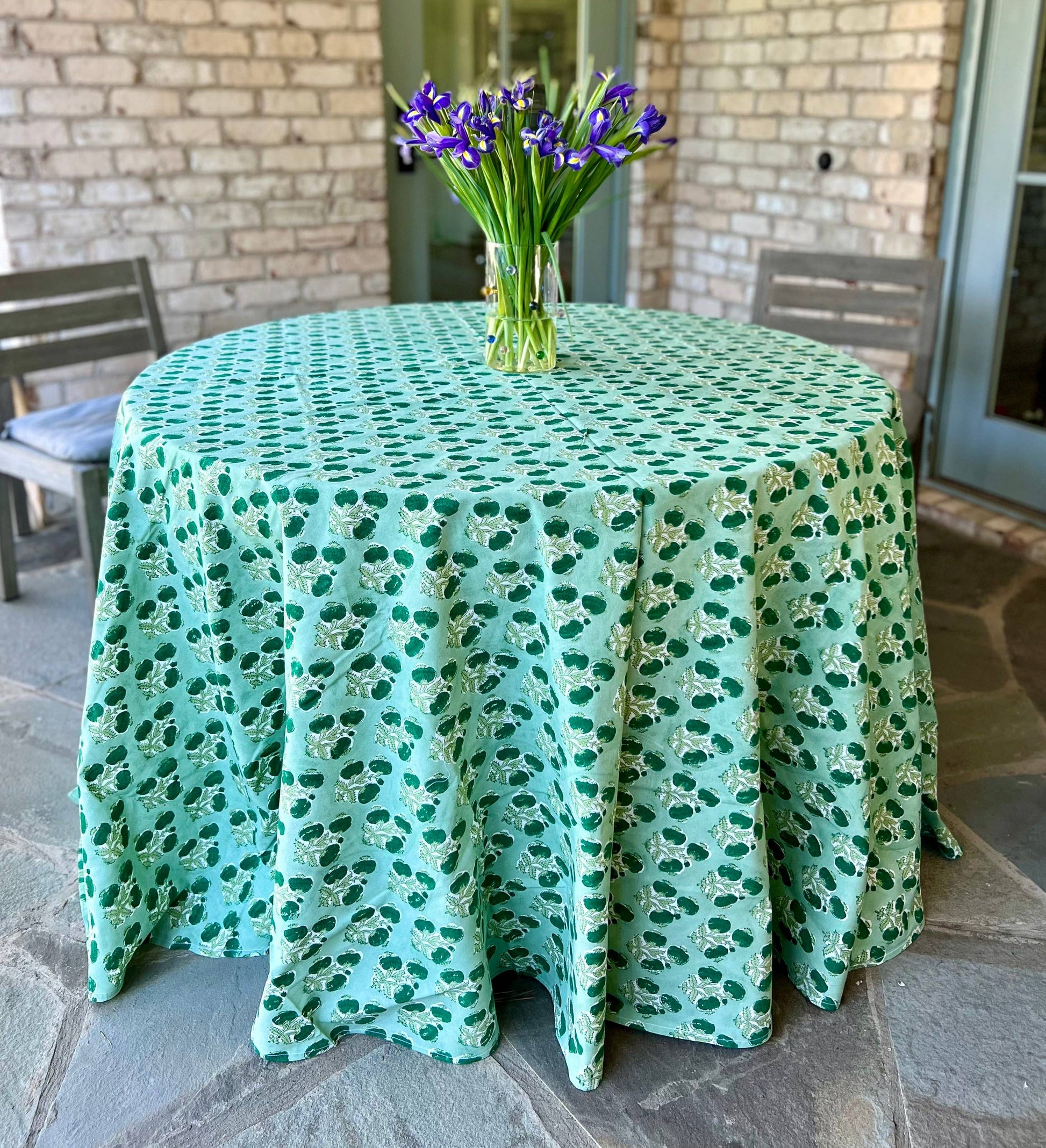 Emerald green Poms tablecloth by Christina Dickson Home, 120x70 inch rectangle, fabric with colorful pom trim for dining table.