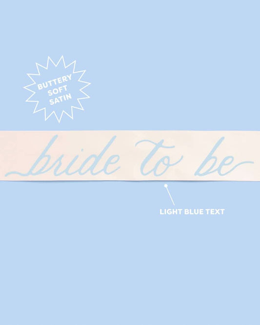 Bride To Be Sash by xo, Fetti with white fabric and gold lettering, designed to be worn around the waist for bridal celebrations.