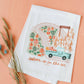 Doe A Deer Autumn is in the Air Flour Sack Towel featuring fall-themed design and soft fabric, ideal for kitchen decor and baking.