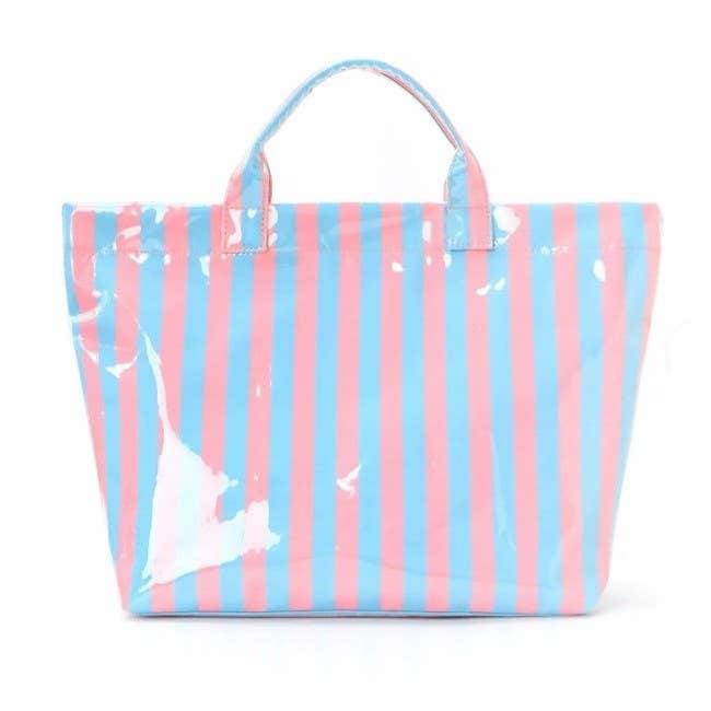 Large blue and pink striped vinyl tote bag by JOSSLYN with sturdy handles and spacious interior for everyday use.