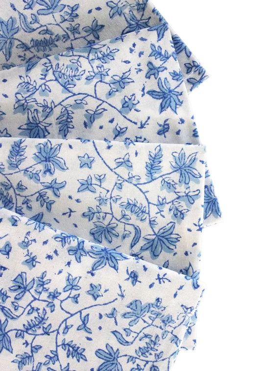 Set of four Christina Dickson Home Whimsy Floral Sorrento Blue napkins with vibrant floral pattern on soft fabric.