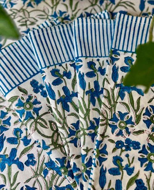 Set of four blue Pinwheel Napkins by Christina Dickson Home, featuring a colorful pinwheel pattern on soft fabric.