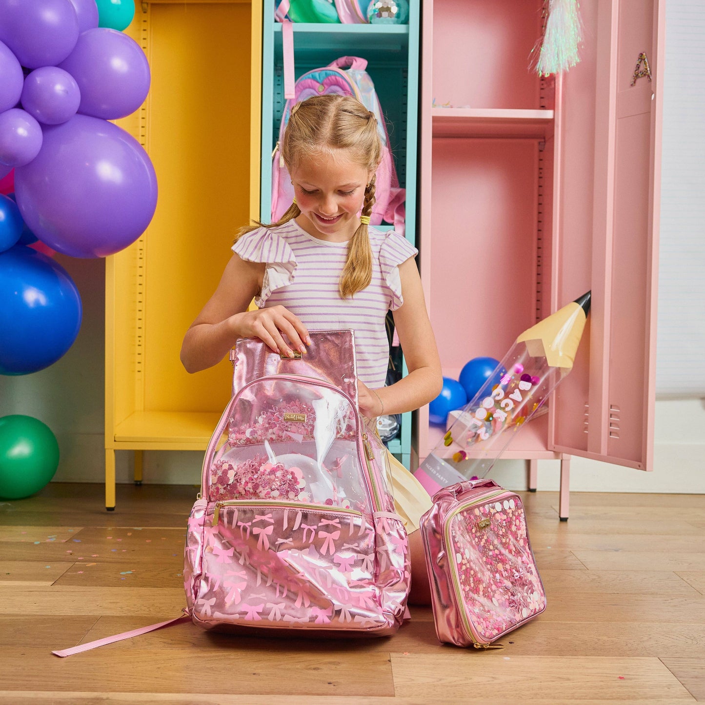 Pink lunchbox decorated with bows and confetti design by Packed Party, perfect for kids or teens.