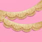 Gold scallop fringe banner by xo, Fetti featuring shimmering scalloped edges and layered gold fringe for festive decor.
