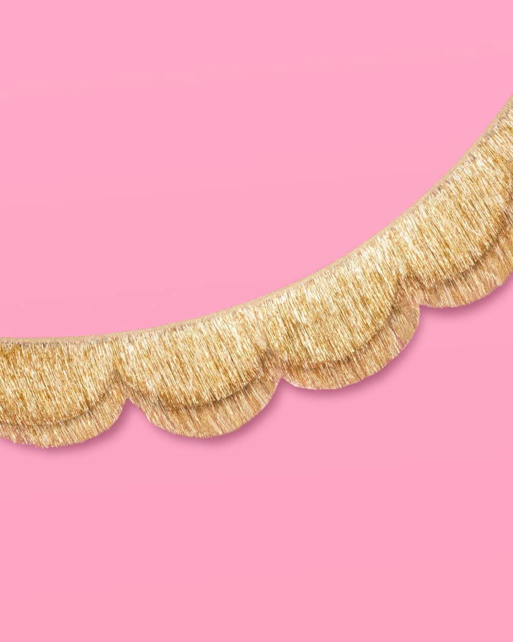 Gold scallop fringe banner by xo, Fetti featuring shimmering scalloped edges and layered fringe for festive decoration.