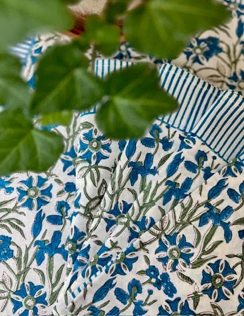 Set of four blue Pinwheel Napkins by Christina Dickson Home featuring colorful pinwheel patterns on soft fabric.